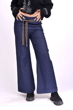 Vedere din spate a blugilor largi, talie elastică evidențiată și cusături contrast.