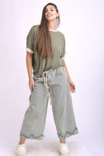 Vedere laterală a blugilor largi cu volan la tiv și talie elastică, look casual modern.