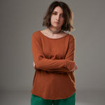 Detaliu bluză cărămizie cu croială rotunjită la bază și guler larg