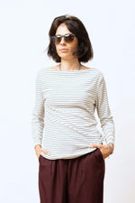 Bluză damă albă cu dungi negre subțiri, mâneci lungi și decolteu rotund larg.