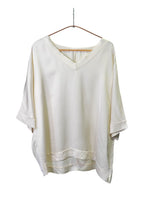 Bluză lejeră crem cu decolteu în V și croială relaxată, confecționată din material satinat cu finisaj delicat.