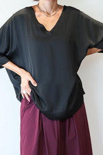 Bluză elegantă neagră, purtată lejer peste fustă vișinie