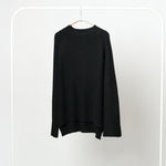 Bluză neagră din tricot raiat cu model ajurat și guler înalt, expusă pe umeraș