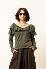 Bluză verde cu volane pe umeri și mânecă lungă, decolteu larg, vedere frontală.