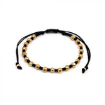 Brățară handmade cu șnur negru reglabil și sfere aurii, fotografiată pe fundal alb