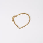 Brățară flexibilă din mărgele metalice aurii, aranjate dens, cu finisaj lucios.