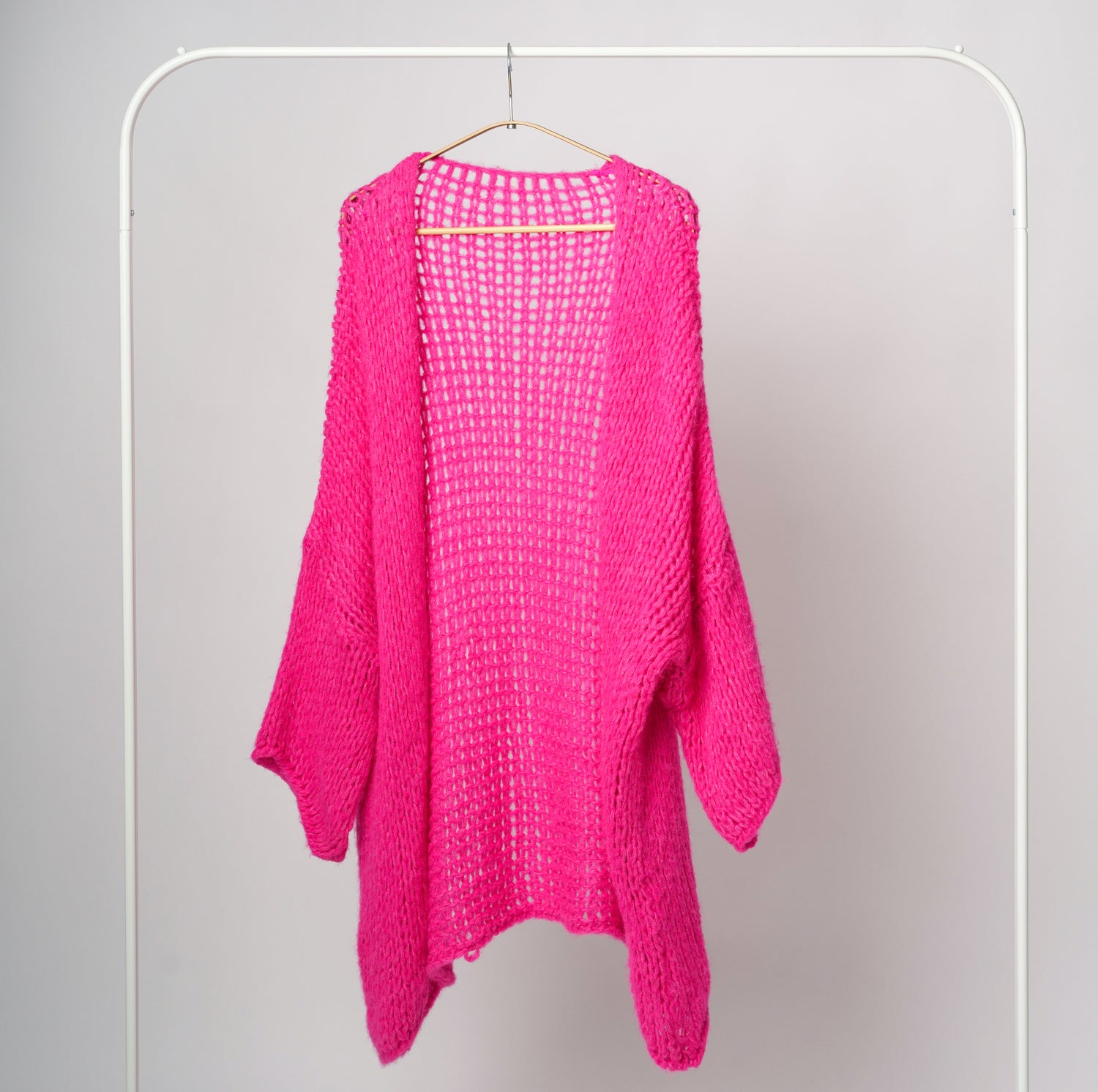 Cardigan fucsia din tricot cu ochiuri largi, purtat cu umeri căzuți