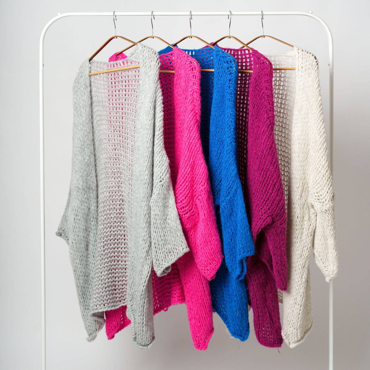 Cardigane croșetate cu ochiuri largi în mai multe culori: alb, roz, albastru și gri