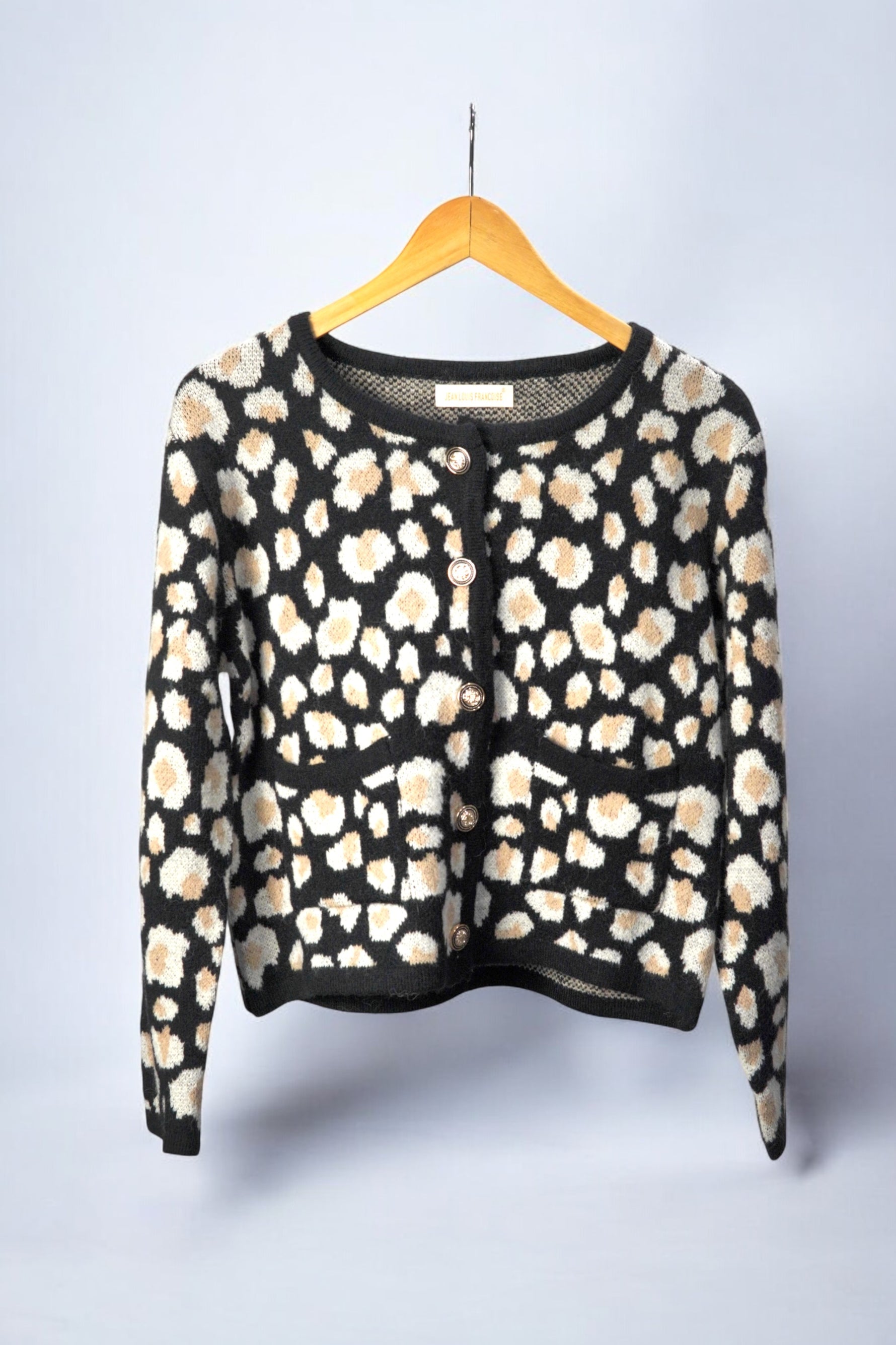 Cardigan cu imprimeu animalier în nuanțe de bej și alb pe fundal negru, vedere frontală, închis cu nasturi aurii decorativi.