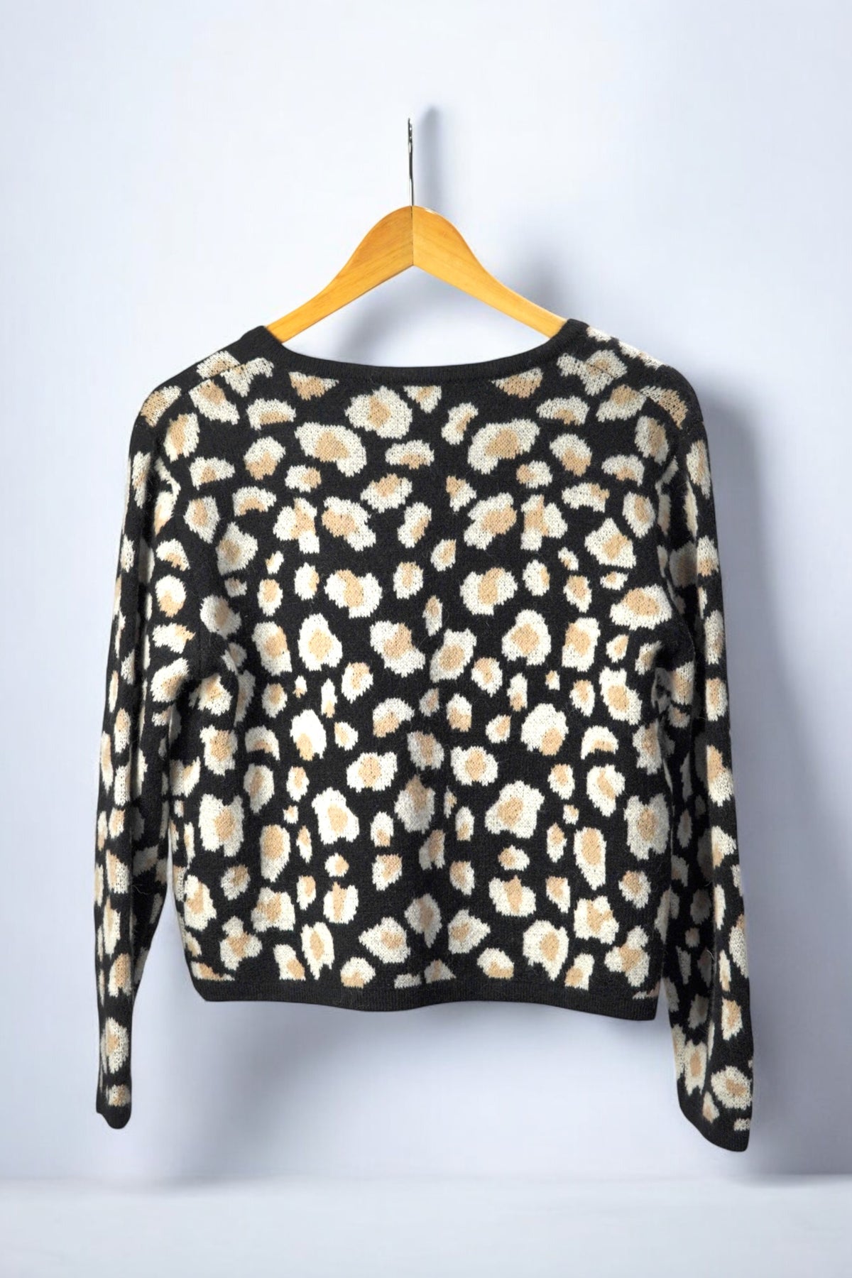 Vedere din spate a unui cardigan cu imprimeu animalier, în nuanțe de bej, alb și negru.