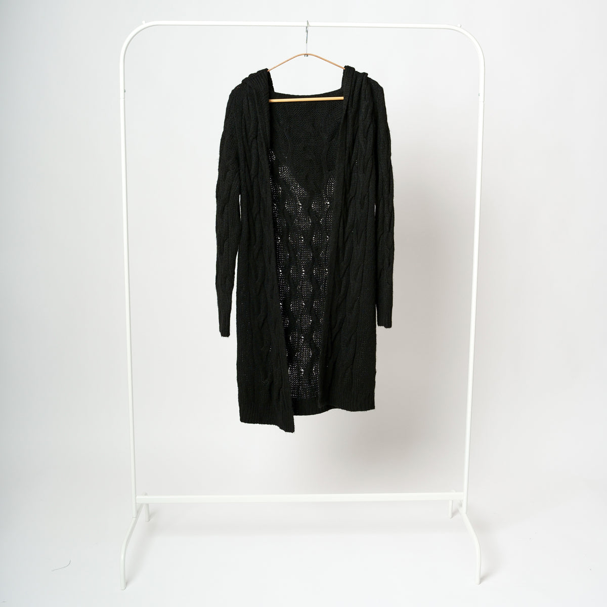 Cardigan lung tricotat negru, cu glugă și croială deschisă, fără închidere.