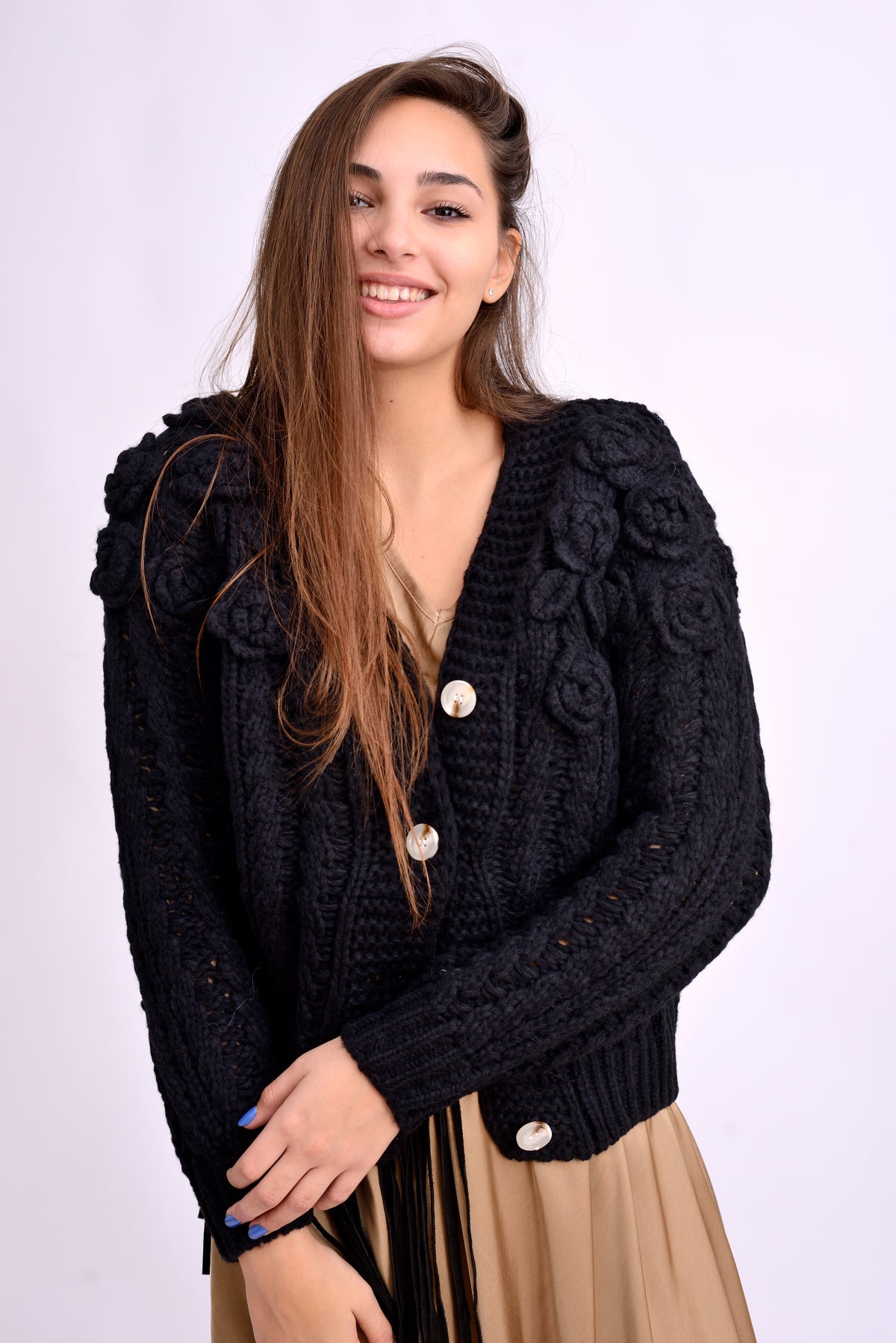 Cardigan tricotat negru cu flori mari aplicate, croială scurtă, purtat pe model.