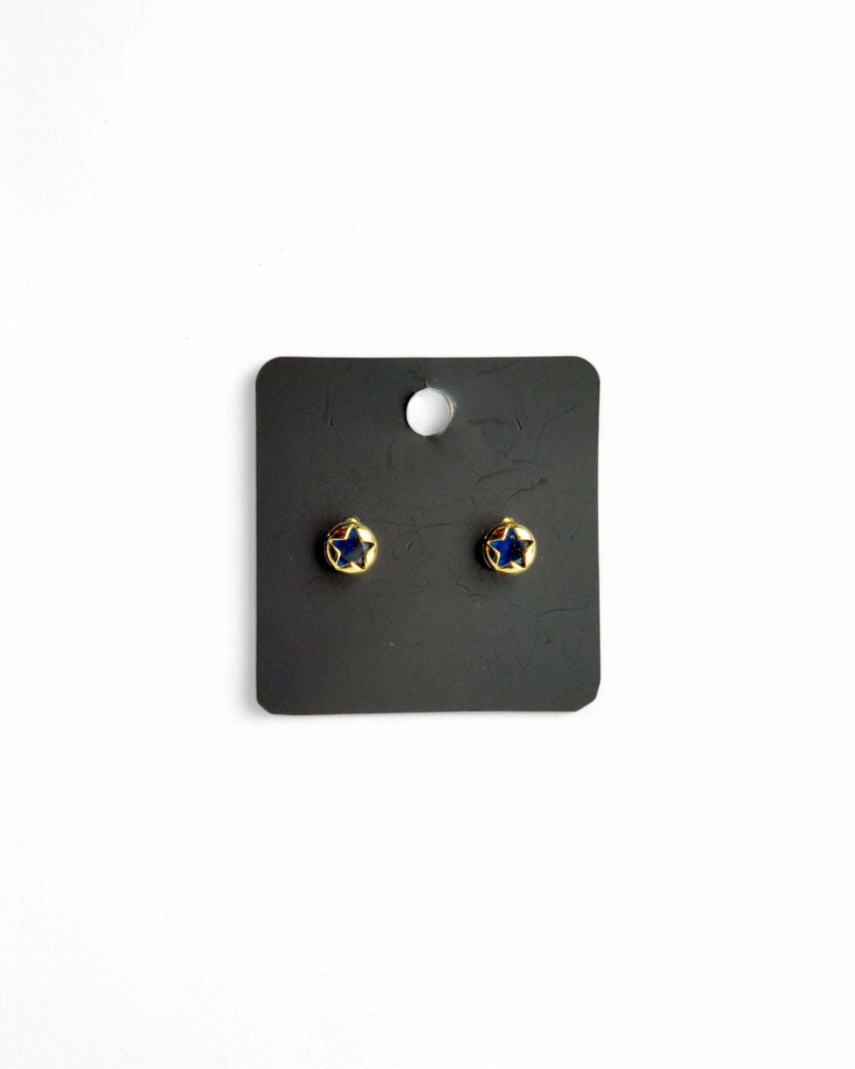 Cercei aurii cu steluță albastră, prezentați pe un card de bijuterii negru, cu fundal alb.