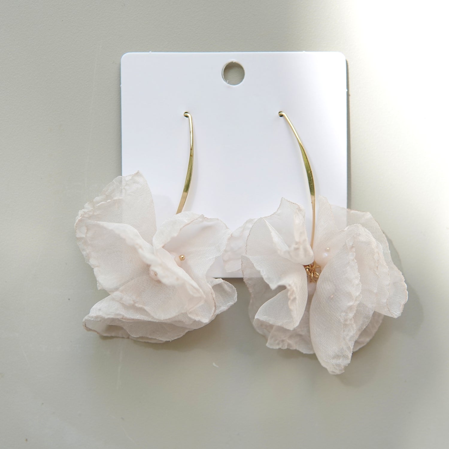 Cercei eleganți din oțel inoxidabil, cu flori satinate crem și detaliu perlat.