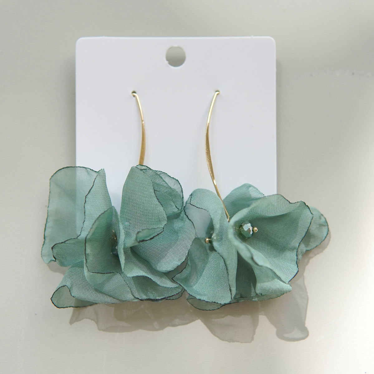 Cercei fashion din oțel inoxidabil, cu flori satinate verzi și detalii decorative fine.