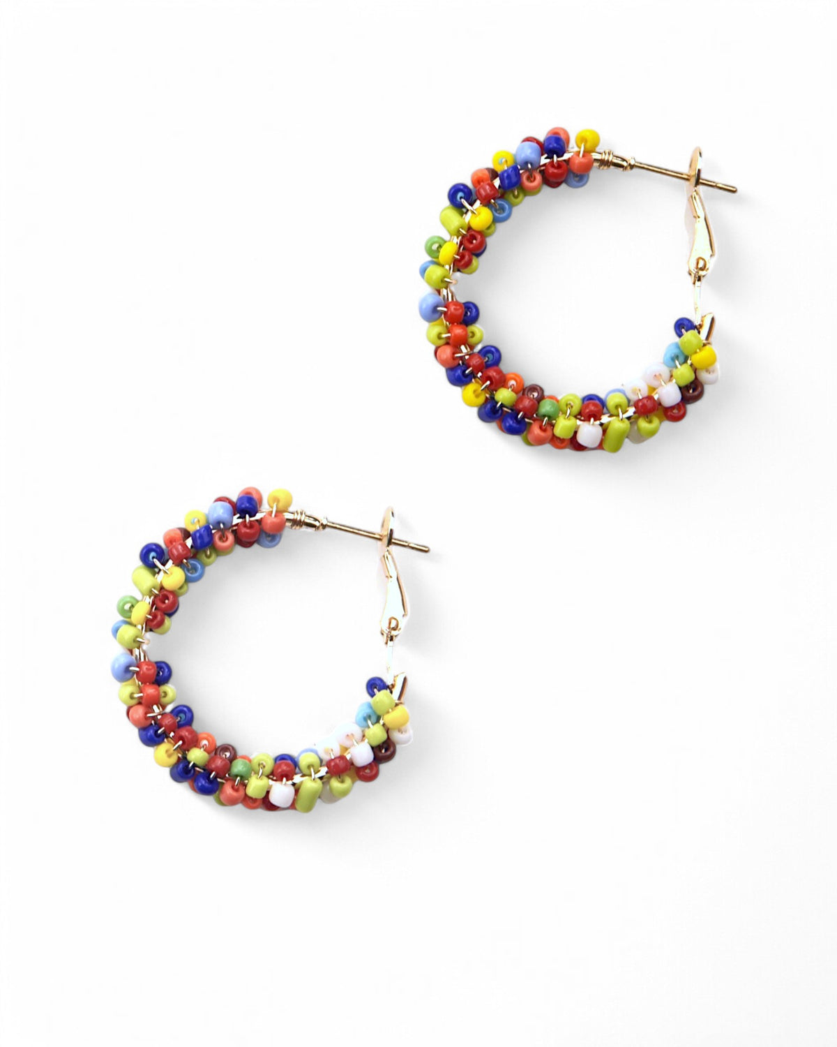 Cercei hoop mici văzuți de sus, dezvăluind structura metalică și mărgeluțele viu colorate.