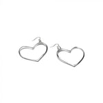 Cercei din aluminiu reciclat, în formă de inimă, fotografiați pe fundal alb, evidențiind detaliile și forma elegantă.