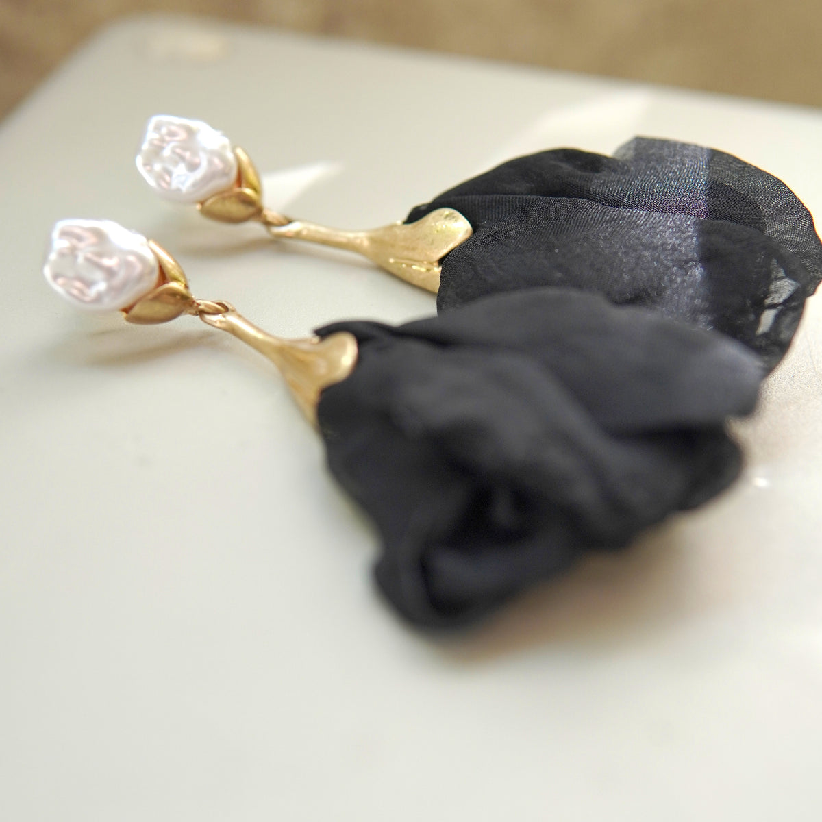 Cercei eleganți din oțel inoxidabil cu perlă albă și floare textilă satinat neagră, detaliu lateral.