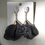 Vedere frontală a unei perechi de cercei cu perlă albă și floare din material satinat negru.