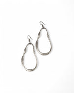 Cercei ovali cu onduleu, metalizați, așezați pe fundal alb