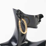 Cercei ovali răsuciți din oțel inoxidabil auriu, purtați pe manechin