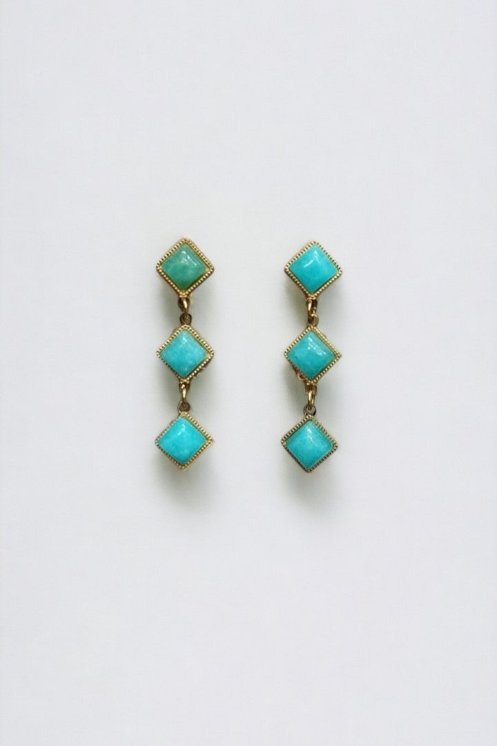 Cercei verticali scurți cu cristale turcoaz în formă de romb, încadrați de ramă aurie, prindere cu șurub.