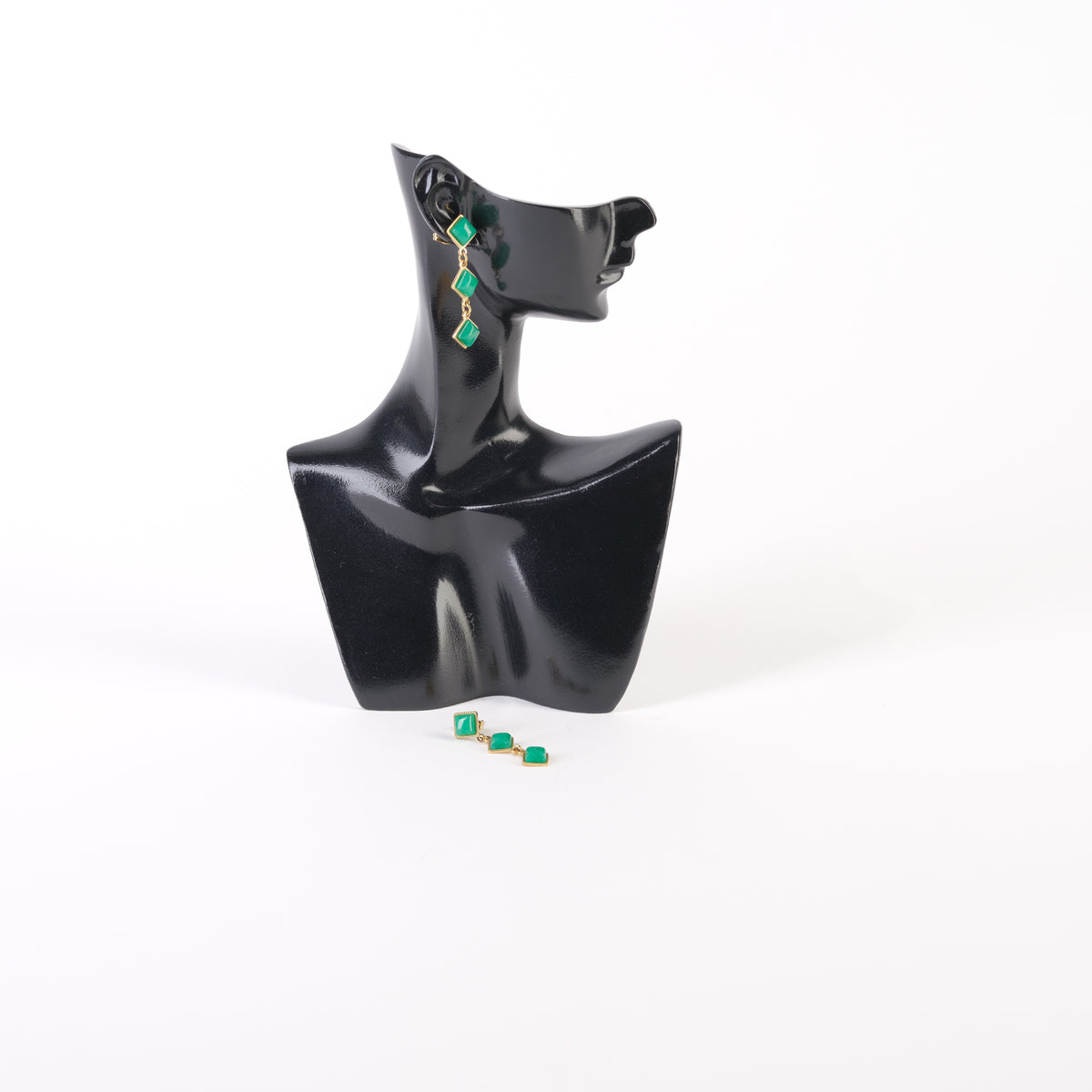 Cercei scurți cu trei romburi din cristale verzi, ramă aurie, prezentați pe suport de expunere, închidere tip șurub.