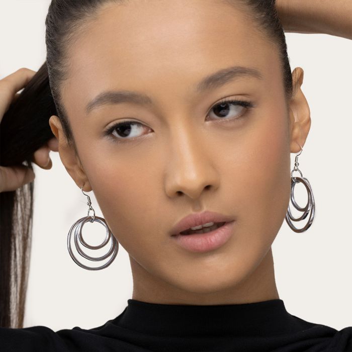 Cercei cu trei cercuri subțiri, purtați de un model cu păr prins, look elegant și minimalist