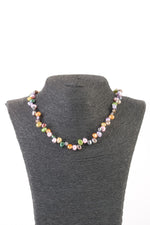 Colier cu perle de cultură multicolore, de forme neregulate, expus pe suport negru, cu închizătoare metalică tip carabină.