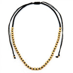 Colier handmade cu sfere aurii, realizat din aluminiu reciclat și fir de macrame, prezentat pe fundal alb