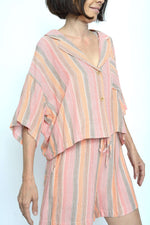 Vedere laterală a compleului cu croială lejeră și imprimeu în dungi fine.