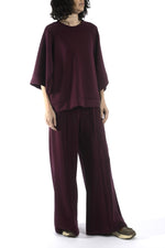 Vedere laterală a compleului bordo, evidențiind croiala fluidă și căderea materialului.