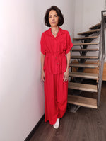 Compleu roșu deschis din material satinat, cu bluză ajustabilă în talie și pantaloni palazzo