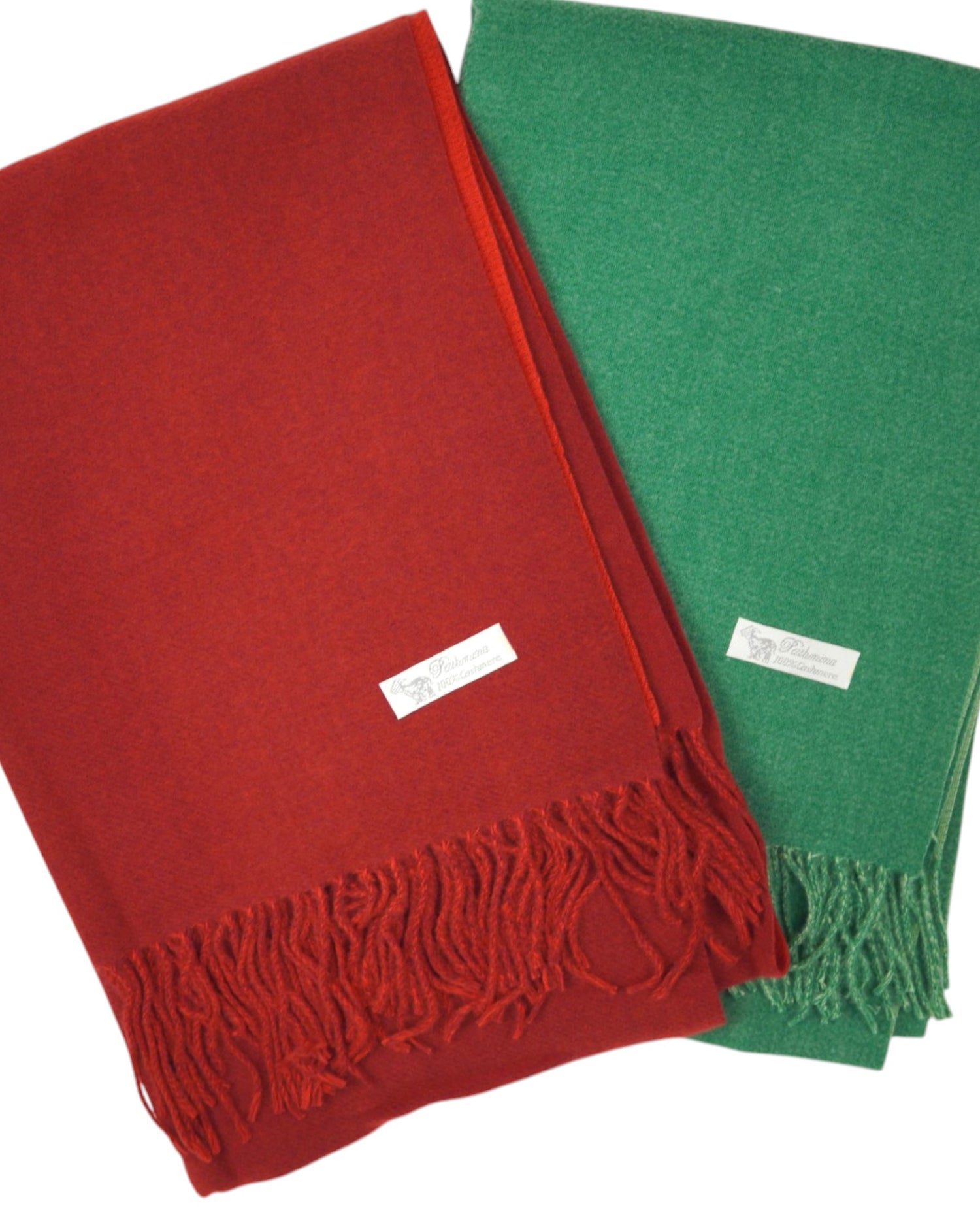Fular pashmina verde și roșu prezentate împreună, pliate elegant pe fundal alb, cu franjuri decorative.