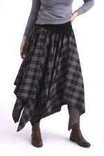 Fustă în colțuri, cu tiv asimetric și talie elastică, vedere laterală, evidențiind volumul fluid al materialului.