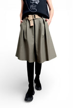 Fustă midi evazată neagră, purtată cu top imprimat și curea textilă, cu volum lejer și cădere fluidă.