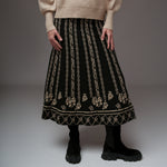 Fustă midi neagră cu motive florale și elemente grafice bej, croială evazată și talie elastică.