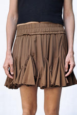 Fustă mini maro cu croială vaporoasă și volane accentuate, purtată cu pantofi sport