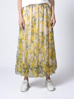 Fustă lungă plisată, cu imprimeu de lămâi galbene și talie elastică, pe fundal alb semi-transparent