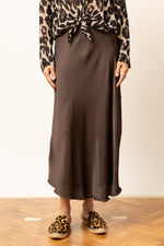 Detaliu fustă satinatã midi maro, evidențiind textura netedă a materialului.