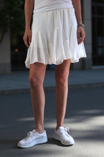 Fustă scurtă albă din poliester elastic, cu volane decorative și talie lejeră