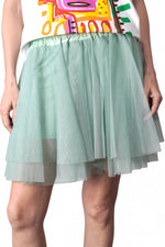 Prim-plan cu fusta din tul verde pastel, evidențiind textura fină a materialului și dublura satinat-lucioasă.