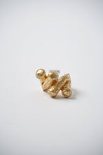 Inel masiv ajustabil, din metal auriu, cu forme geometrice neregulate și aspect artistic.