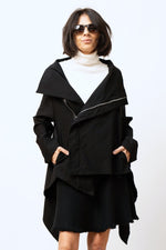 Jachetă asimetrică neagră din viscoză, cu fermoar oblic și croială modernă, purtată pe model.