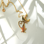 Pandantiv pisică aurie din oțel inoxidabil, surprins în detaliu pe fundal luminos.