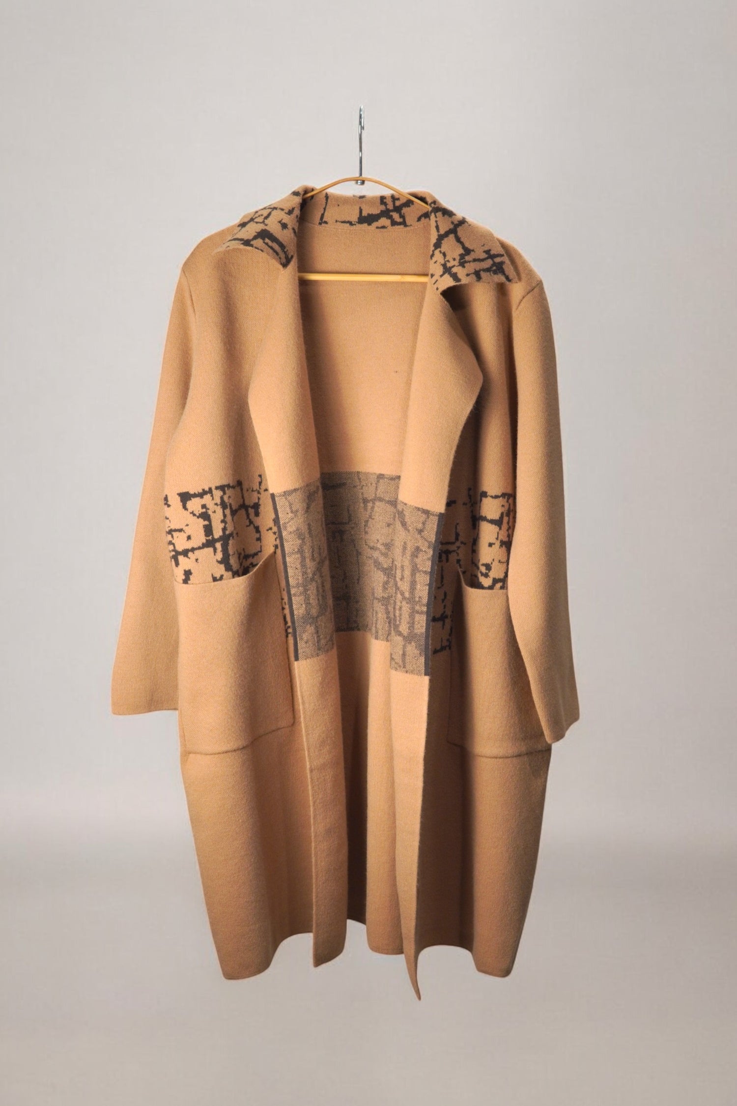 Palton bej elegant cu imprimeu abstract negru, model larg și buzunare aplicate.