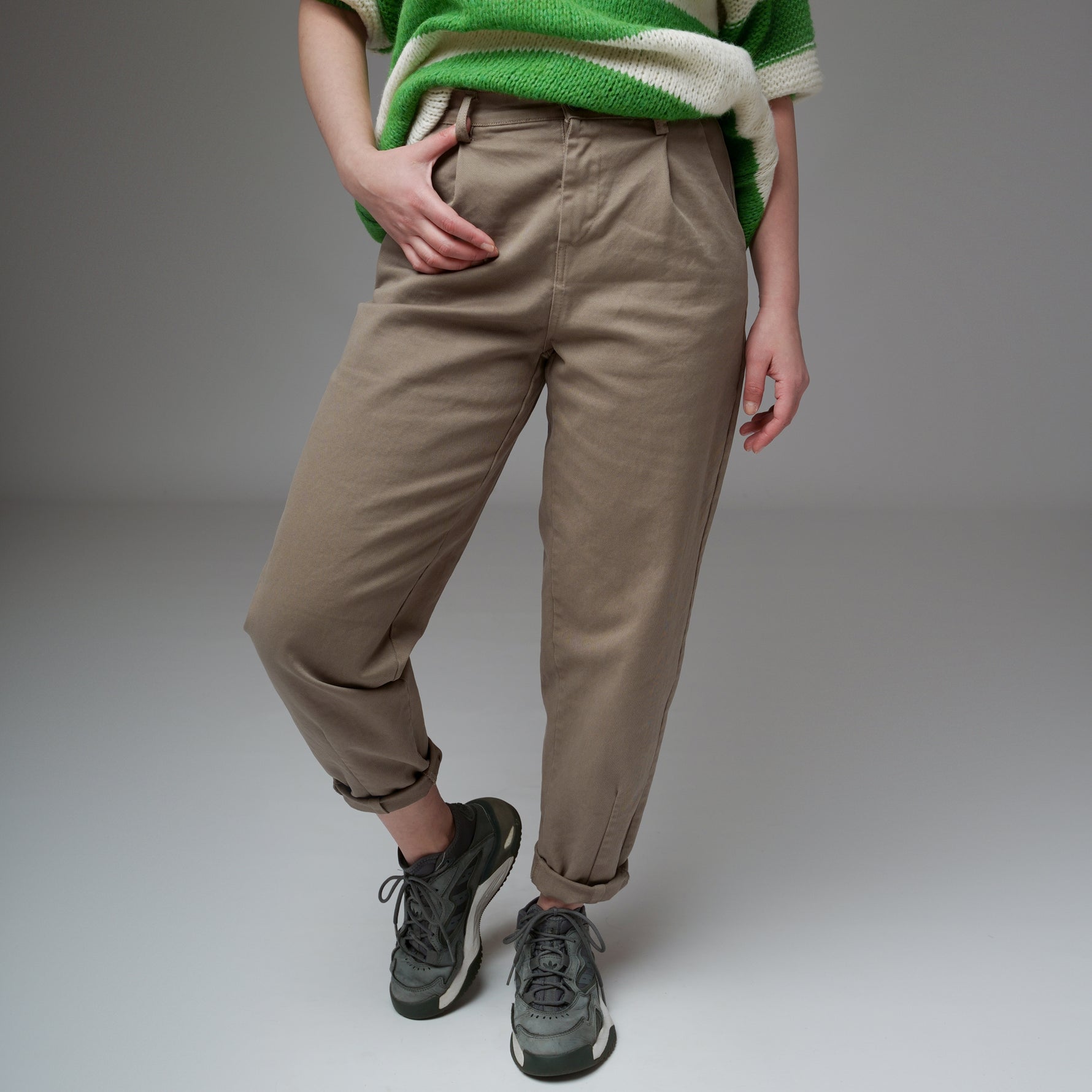 Pantaloni grej cu aspect baggy, fotografiați în studio, cu croială conică și talie înaltă.