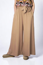 Pantaloni largi bej cu talie elastică și cordon reglabil, din material fluid.