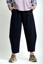 Ținută completă cu pantaloni lejeri și top simplu, într-un stil urban relaxat.