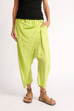 Pantaloni pareo din in 100%, verde fosforescent, cu talie elastică, parte frontală petrecută și nasture contrastant.